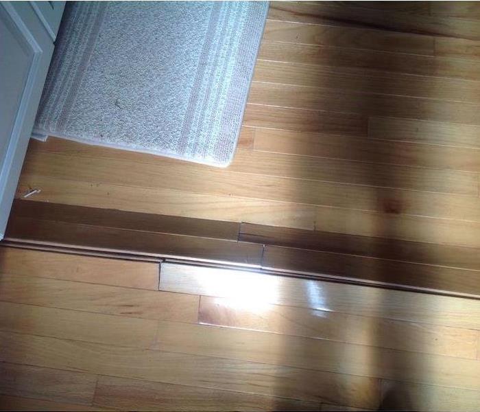 Buckled wood floorboards in a kitchen