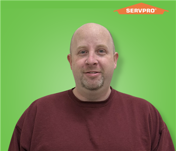 male employee smiling and wearing a red shirt