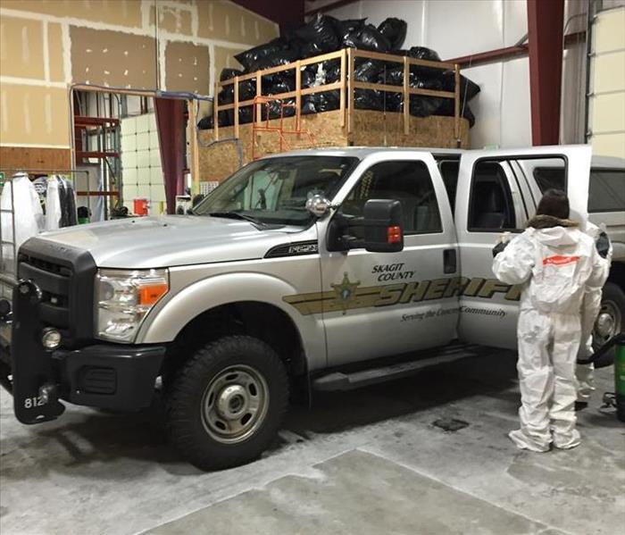 Workers clean an auto from the Sheriff's dept