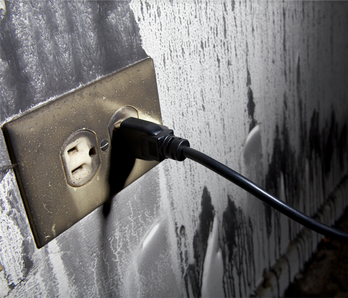 a fire damaged wall outlet covered in soot
