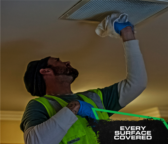 tech cleaning soot from ceiling with cloth