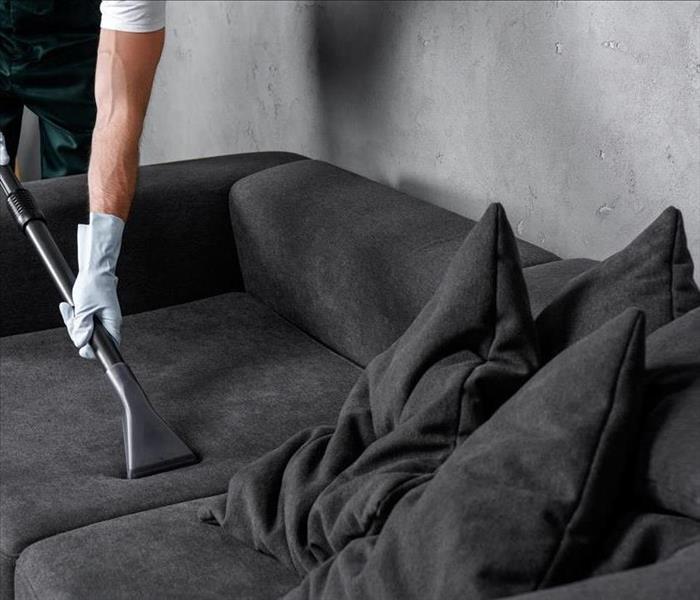 Vacuuming dirty, sooty sofa