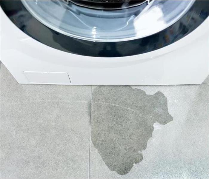 a puddle of water next to a broken washer