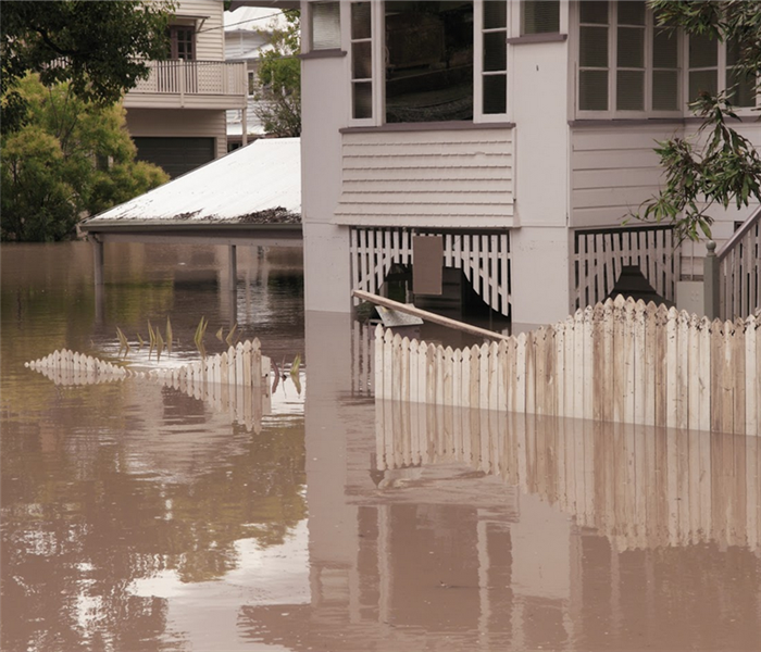 a flooded neighborhood with water up to a fence of a house
