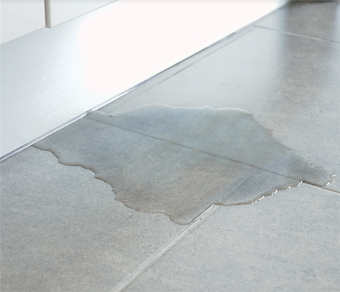 a puddle of water on the tile floor of an office